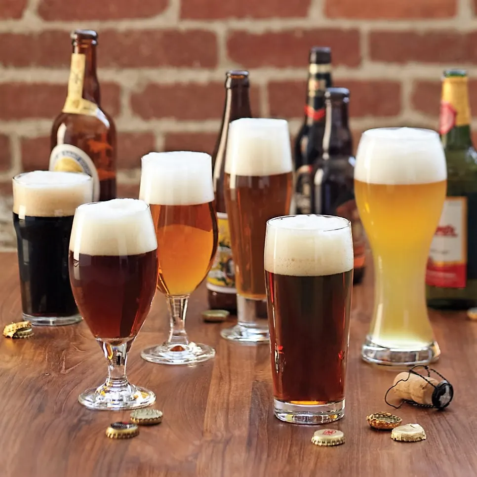 Assorted beer glasses and steins on a wooden bar