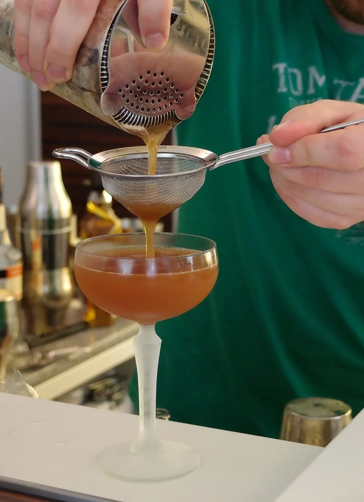 Cocktail shaker and bar tools on a home bar counter