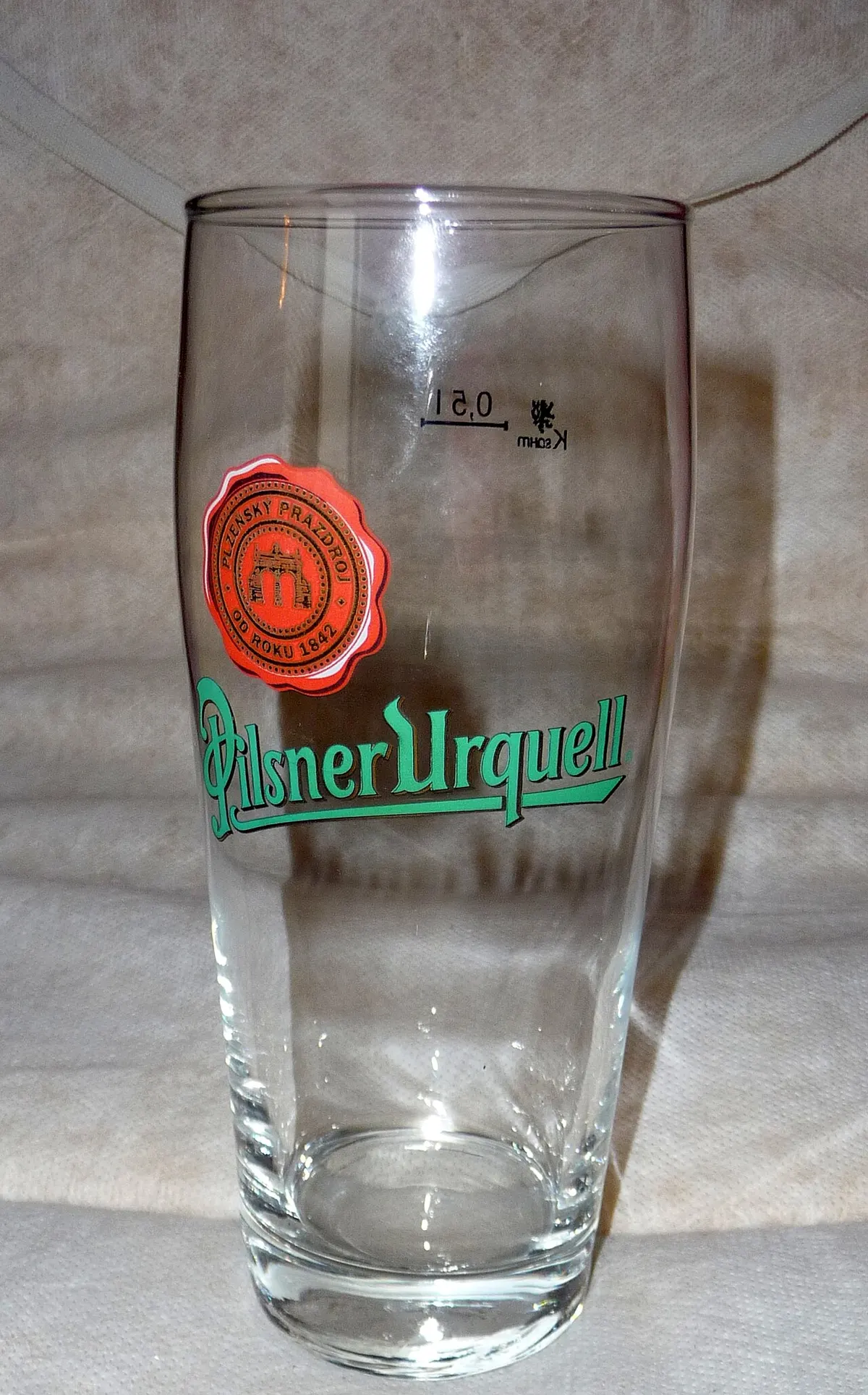 Tall tapered pilsner glass filled with golden lager