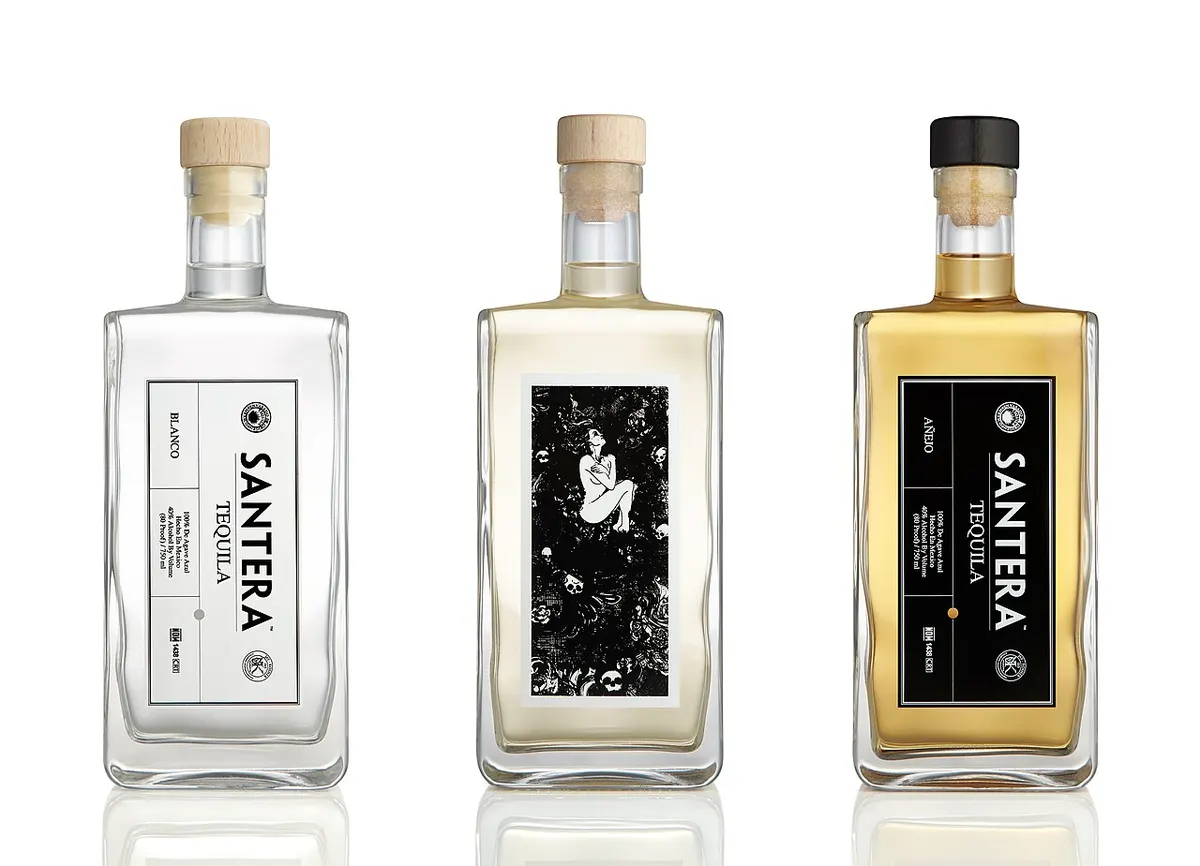 A bottle of blanco tequila with agave leaves
